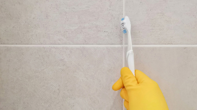 cleaning grout with a toothbrush